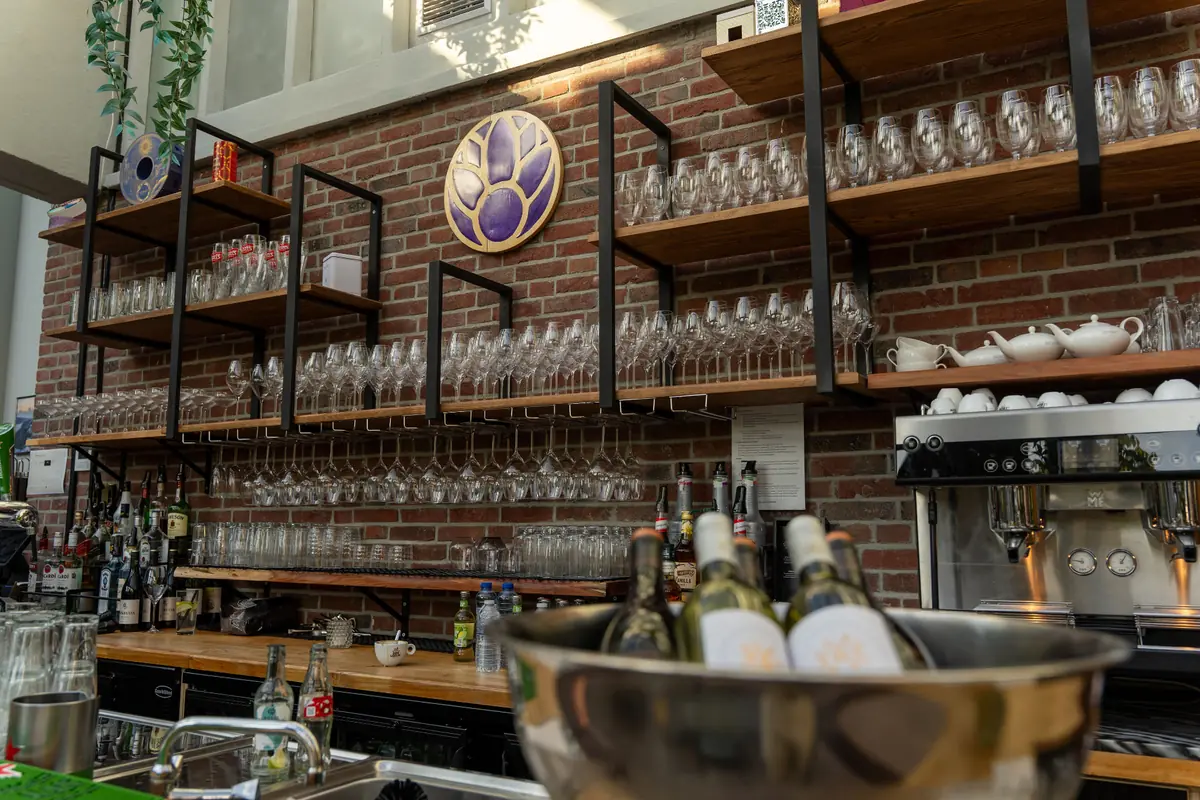 Bar van Brasserie Lenny in Amsterdam Oost met wijnglazen, koffie en wijn.