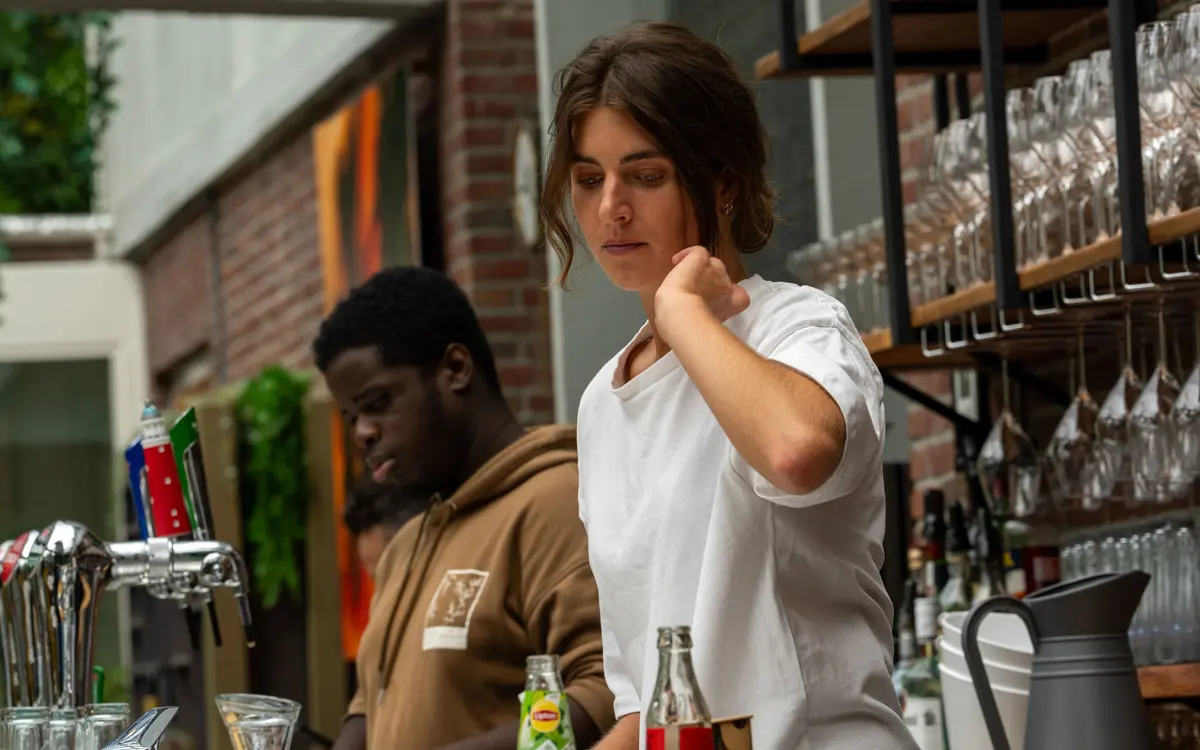 Medewerkers van Brasserie Lenny aan het werk achter de bar in Amsterdam Oost.