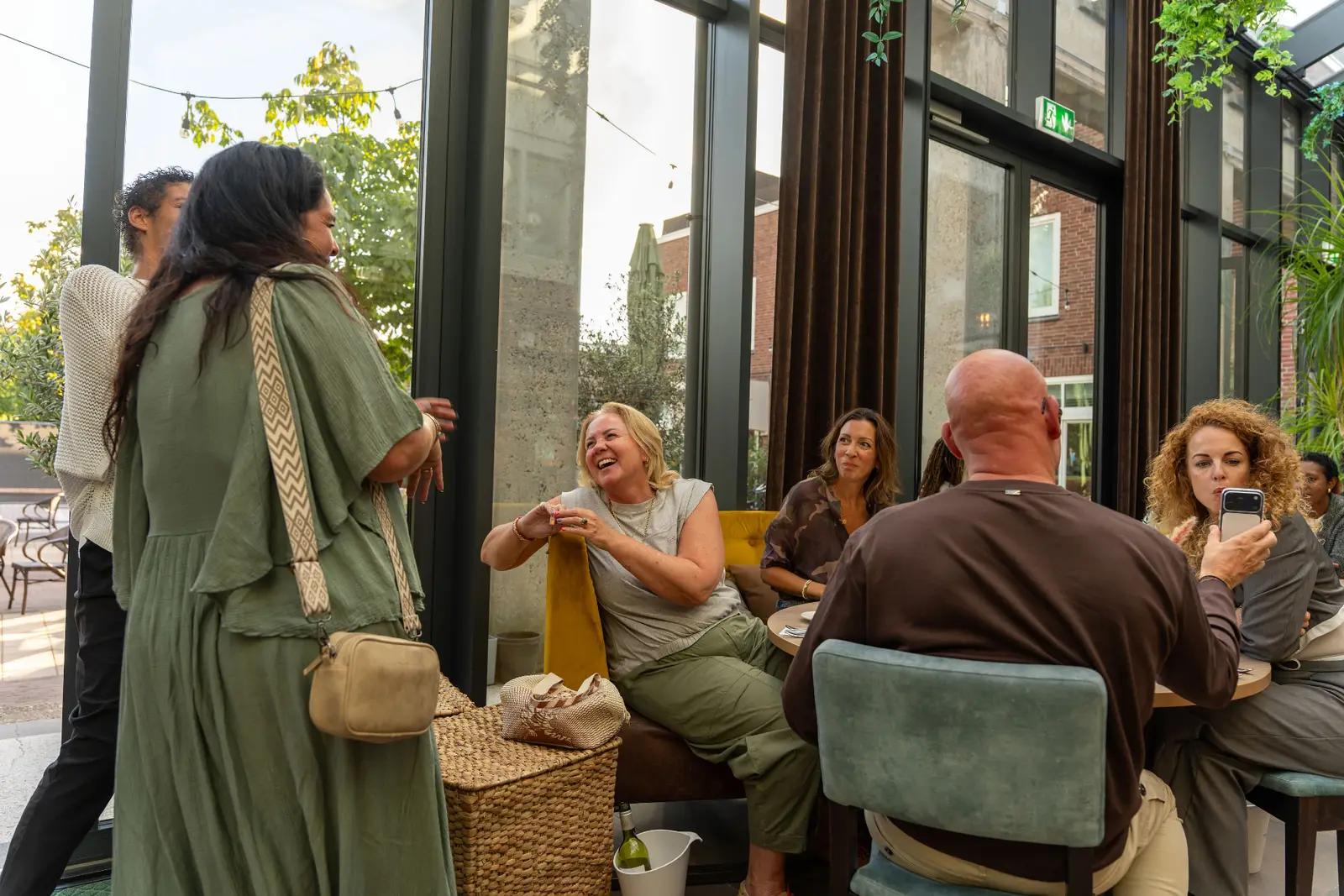Gasten lachen samen aan tafel in Brasserie Lenny in Amsterdam Oost.
