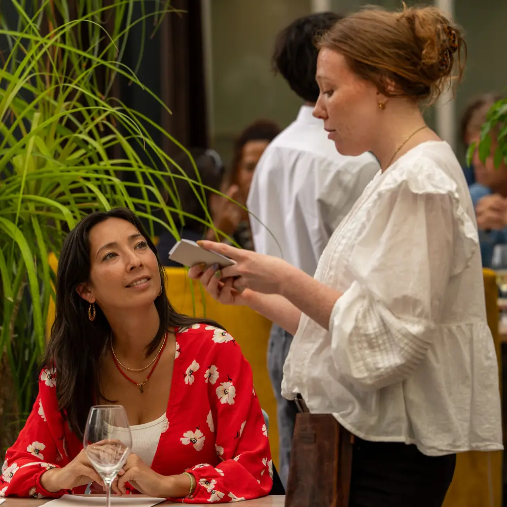 Medewerker neemt de bestelling op bij een gast in Brasserie Lenny, Amsterdam Oost.